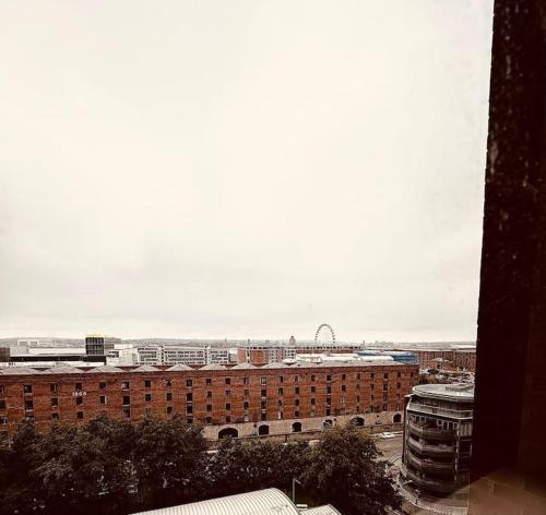 a view of a city with a ferris wheel in the distance at BRAND NEW 5 STAR LUXURY 2 BEDROOM APARTMENT, SLEEPS 6, CENTRAL, WiFI, BIG SMART TV, ALEXA SPEAKERS, EASY ACCESS LOCK BOX ENTRY! in Liverpool