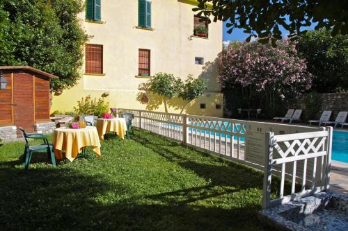 a fence with tables and chairs in front of a building at Hotel San Filis in San Felice del Benaco