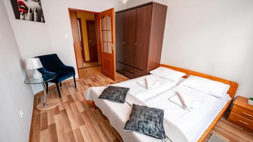 a bedroom with a bed and a table and a chair at Apartamenty Sun & Snow Nad Potokiem in Krynica Zdrój