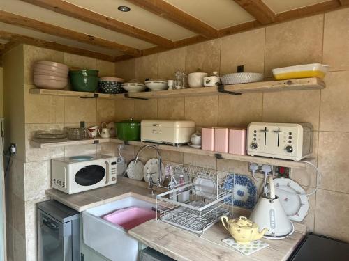cocina con fregadero y microondas en Pond Cottage, en Egerton