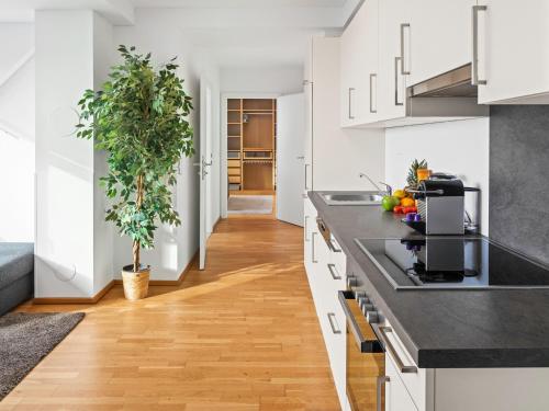 a kitchen with white cabinets and a black counter top at SKY9 Penthouse Apartments in Vienna