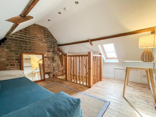 a bedroom with a bed and a brick wall at The Snug in Southwell