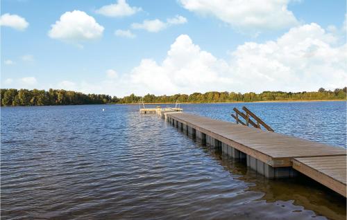 a dock on a large lake with clouds in the sky at 4 Bedroom Awesome Home In Jönköping in Jönköping