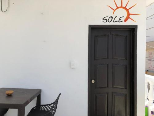 a black door with a sale sign next to a table at Posada DORA in Isla Mujeres