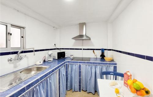 eine blau-weiße Küche mit einem Waschbecken und einem Tisch in der Unterkunft Lovely Home In Olvera With Wi-fi in Olvera