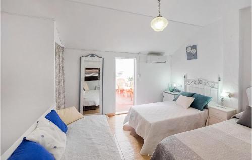 ein weißes Schlafzimmer mit 2 Betten und einem Spiegel in der Unterkunft Lovely Home In Olvera With Wi-fi in Olvera