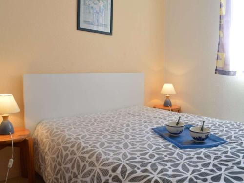een slaapkamer met een bed met twee kommen erop bij Appartement Fréjus, 2 pièces, 4 personnes - FR-1-226A-366 in Fréjus