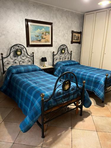 um quarto com 2 camas com edredões azuis em Zagara room em Padule