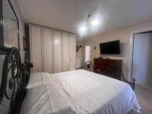 1 dormitorio con 1 cama blanca y TV en Zagara room, en Padule