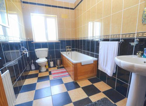 uma casa de banho com uma banheira, um WC e um lavatório. em Ballygarrett Holiday Home em Ballygarrett