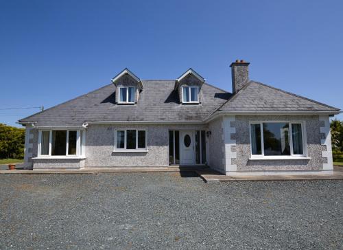 a large brick house with a lot of windows at Ballygarrett Holiday Home by Trident Holiday Homes in Ballygarrett