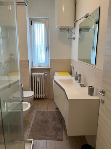 a bathroom with a sink and a toilet and a mirror at La nostra casa la vostra casa Cir00023 in Saint Vincent