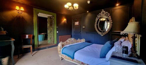 a bedroom with a bed and a mirror at Le Petit Chateau & William de Percy in Otterburn