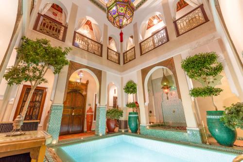 une piscine intérieure dans un bâtiment avec des plantes en pot dans l'établissement Riad Hikaya, à Marrakech