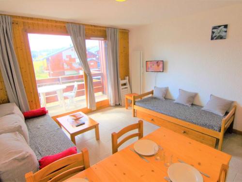 un salon avec un canapé et une table dans l'établissement Studio cabine cosy avec balcon, proche du centre des Saisies - 4 pers, 2 étoiles - FR-1-594-142, à Hauteluce