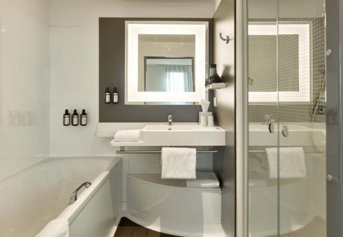 a bathroom with a tub and a sink and a shower at B&B HOTEL Vélizy Est in Vélizy-Villacoublay