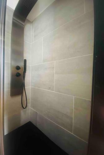 La salle de bains est pourvue d'une douche et d'un téléphone mural. dans l'établissement Paisible F2 Ensoleillé Vue Lac, à Gérardmer