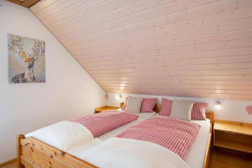 バート・ベリンゲンにあるFerienwohnung Atelierのベッドルーム1室(赤と白の枕が備わるベッド1台付)