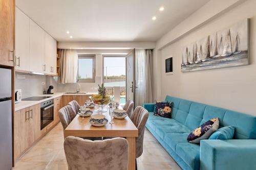 sala de estar con sofá azul y mesa en Modern Family apartment Ewa with pool, dining area on Crete coast, en Stavromenos