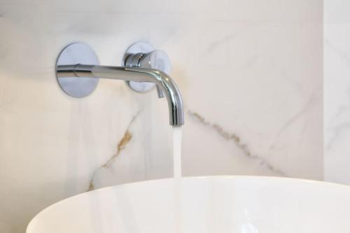 a sink with a faucet in a bathroom at Modern Family apartment Ewa with pool, dining area on Crete coast in Stavromenos