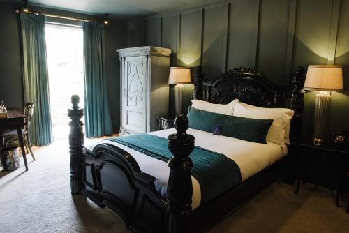 a bedroom with a large bed with green walls at Le Petit Chateau & William de Percy in Otterburn