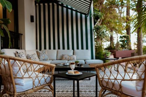 a patio with a couch and two chairs and a table at Hotel Estepona Plaza in Estepona