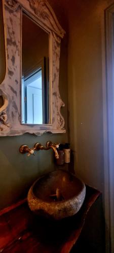 a bathroom with a stone sink and a mirror at Le Petit Chateau & William de Percy in Otterburn
