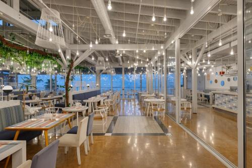 a restaurant with tables and chairs and a view of the ocean at Ramada Plaza Antalya in Antalya