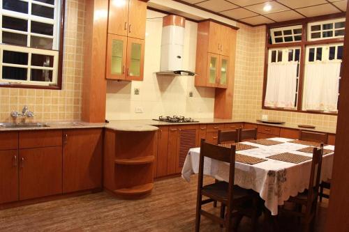 a kitchen with a table and a kitchen with wooden cabinets at Cafe Shillong Bed and Breakfast in Shillong