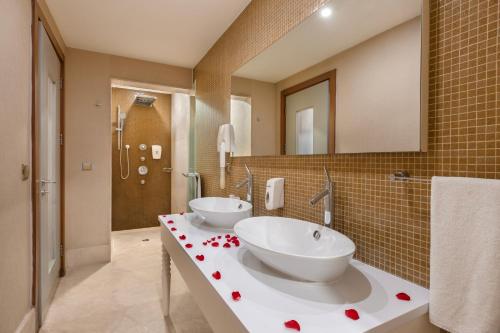two sinks in a bathroom with red hearts on the counter at Ramada Plaza Antalya in Antalya