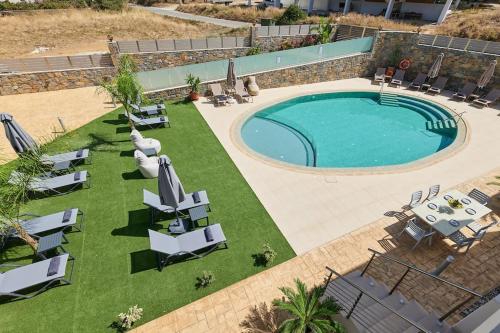 an overhead view of a swimming pool with chaise lounge chairs and a pool at Modern Family apartment Ewa with pool, dining area on Crete coast in Stavromenos