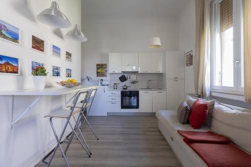 a white living room with a couch and a kitchen at Le case di Frelli in Palermo