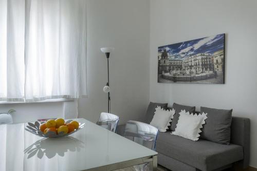 a living room with a table and a couch at Le case di Frelli in Palermo