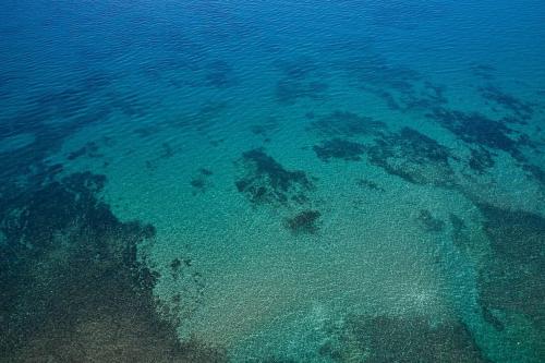 an aerial view of the ocean with reefs at Modern Family apartment Ewa with pool, dining area on Crete coast in Stavromenos