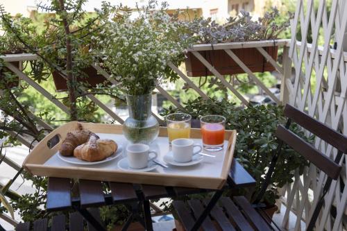 una mesa con una bandeja de comida y dos vasos de zumo de naranja en Le case di Frelli, en Palermo