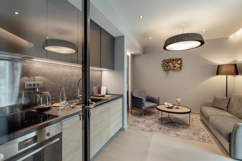 a kitchen and living room with a couch and a table at Garni Hotel Kruso in Herceg-Novi