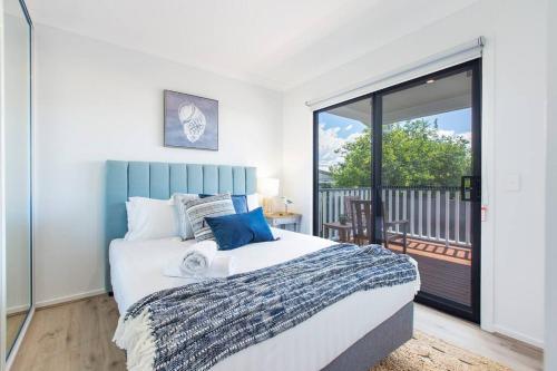 a bedroom with a large bed and a balcony at 'Redcliffe Retreat' Moreton Bay Coastal Cottage in Redcliffe