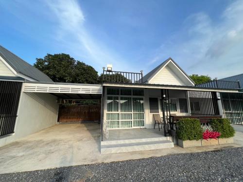 a house with a porch with a patio at Nuttida Resort ณัฐธิดา รีสอร์ท in Ban Khae Taphao