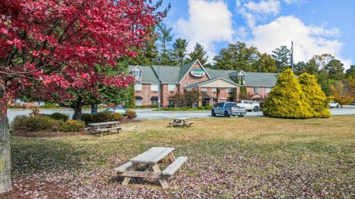 a picnic table in a park in front of a building at Mountain Inn & Suites Flat Rock in Flat Rock