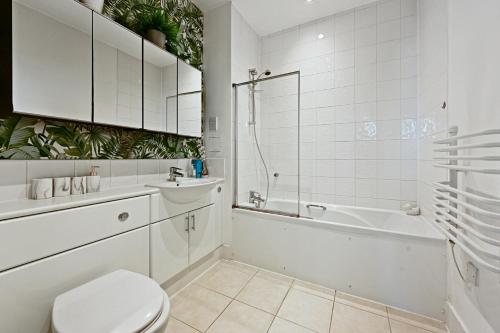 a bathroom with a toilet and a tub and a sink at Luxury 2 Bedroom Penthouse In Chertsey in Chertsey