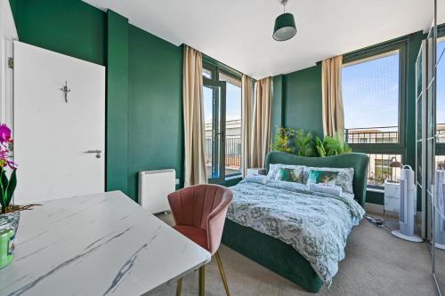 a green bedroom with a bed and a table at Luxury 2 Bedroom Penthouse In Chertsey in Chertsey