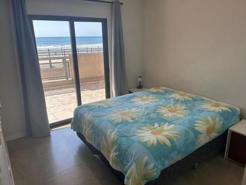 a bedroom with a bed and a view of the beach at APARTAMENTO FRENTE MAR in Itapema