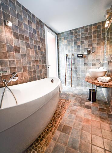 a bathroom with a tub and a sink at Hôtel Les Frères Ibarboure in Bidart