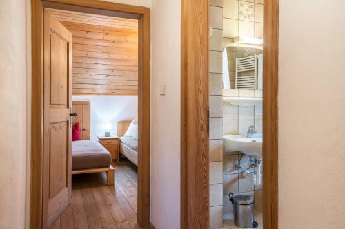 pasillo con baño con lavabo y dormitorio en Ronacherhof Apt Ringelblume, en Auna di Sopra