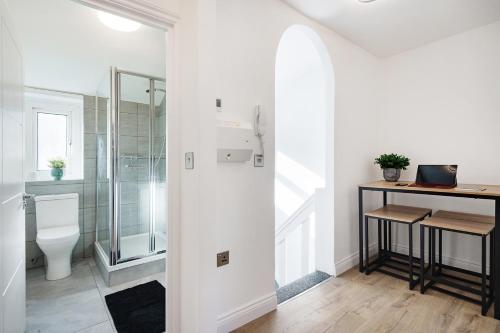 a bathroom with a toilet and a glass shower at London Paddington Station Apartments in London