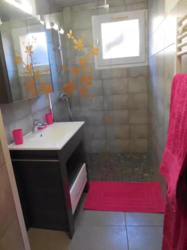 La salle de bains est pourvue d'un lavabo et d'un tapis rouge. dans l'établissement Le Génépi, à La Plagne Tarentaise