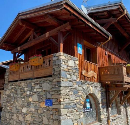 ein großes Holzgebäude mit Balkon oben in der Unterkunft L'edelweiss in La Plagne Tarentaise