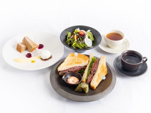 a plate with a sandwich and a salad and a cup of coffee at Hotel The Celestine Tokyo Shiba in Tokyo