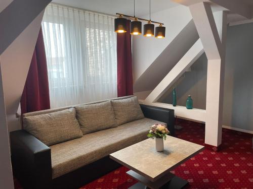 uma sala de estar com um sofá e uma mesa em Hotel Berlin em Leipzig