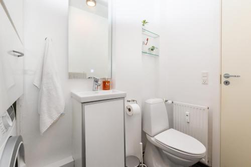 een witte badkamer met een toilet en een wastafel bij 400 meter til Åen - Moderne og fuldt udstyret in Aarhus